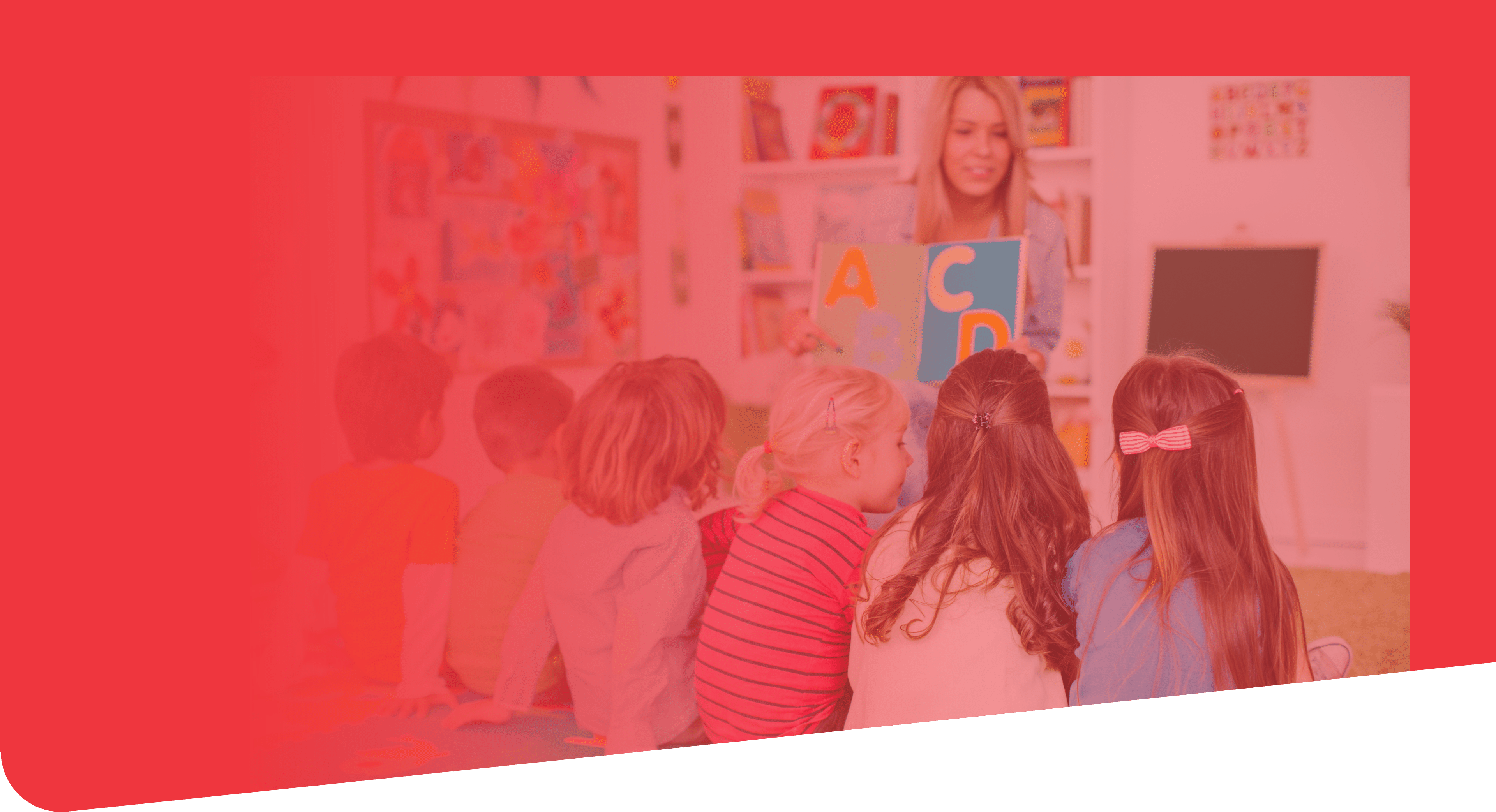 Teacher with a group of preschool children in a nursery. The children are sitting on the floor and listening teacher. Learning letters. In the background we can see a shelf with some, toys, black board and books. View from behind.