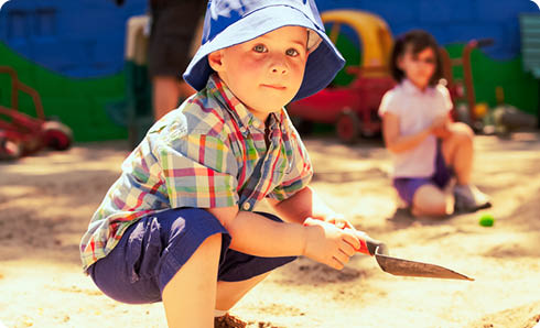 Young boy, playing in the sandbox.