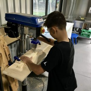 Young person using equipment in the woodwork workshop